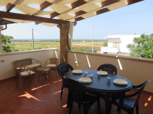 a patio with a table and chairs on a balcony at Le villette Blu di Torre Pali di Salentoinvacanza COM in Torre Pali 