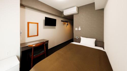 Kleines Zimmer mit einem Bett und einem Schreibtisch. in der Unterkunft Hotel Trend Abeno Tennoji in Osaka
