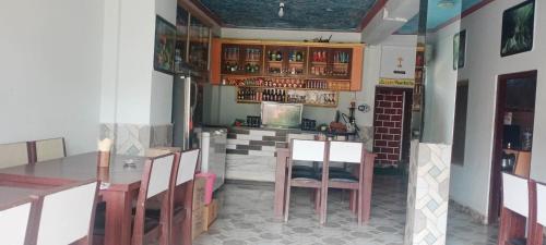 eine Küche mit einem Tisch und Stühlen im Zimmer in der Unterkunft Unique Hotel and Lodge - Pleasure of Homely Stay - in Bandipur
