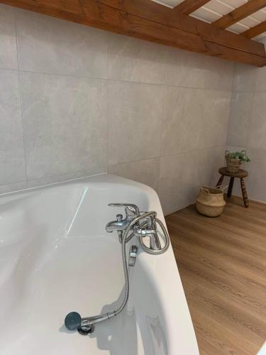 a bath tub with a faucet in a bathroom at Chambre Bordeaux, piscine et spa in Lugon et l’Ile du Carney