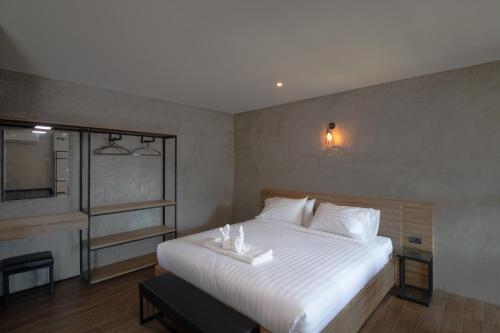 a bedroom with a large white bed and a window at Rabbit Hotel Phimai in Pi Mai