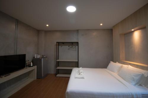 a bedroom with a large bed and a television at Rabbit Hotel Phimai in Pi Mai