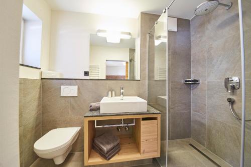 a bathroom with a sink and a toilet and a shower at Fuchs und Gretl in Saalbach Hinterglemm