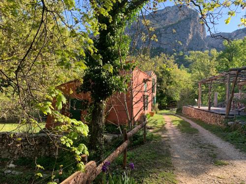 a tree next to a building with a fence at Mymoustiers in Moustiers-Sainte-Marie
