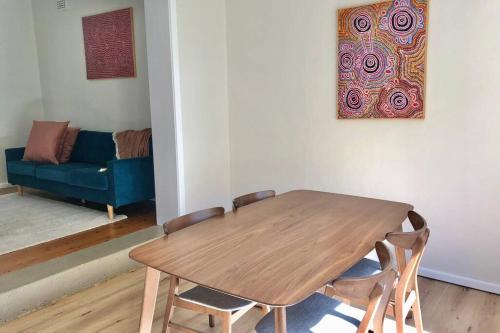 a wooden table and chairs in a living room with a couch at Young Olive in Albury