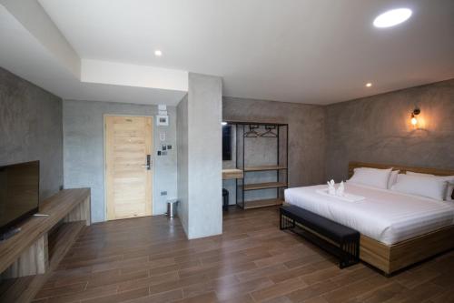 a bedroom with a large bed and a television at Rabbit Hotel Phimai in Pi Mai