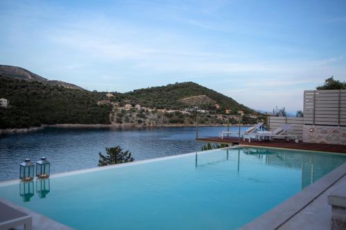 a swimming pool with a view of a body of water at Villa Anthelia-Idyllic view and private access to the sea in Sivota