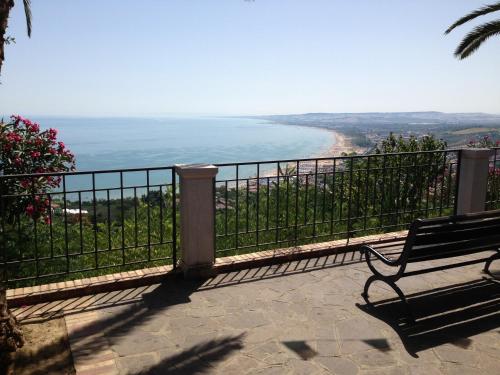 a bench sitting on a balcony looking at a beach at Villa San Giacomo in Scerni