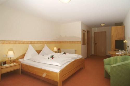 een slaapkamer met een bed, een bank en een stoel bij Land-gut-Hotel Räuber Lippoldskrug in Alfeld