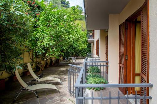 a balcony with chairs and plants and trees at Valle Del Buttero in Capalbio