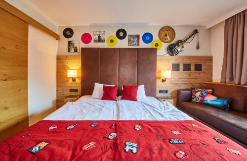 a bedroom with a large red bed and a couch at Fuchs und Gretl in Saalbach Hinterglemm