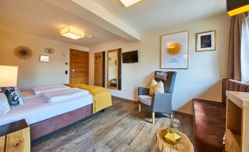 a hotel room with a bed and a chair at Fuchs und Gretl in Saalbach Hinterglemm