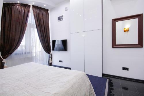a bedroom with a white bed and a window at Panoramic 1-BR apartment in the heart of Odessa in Odesa