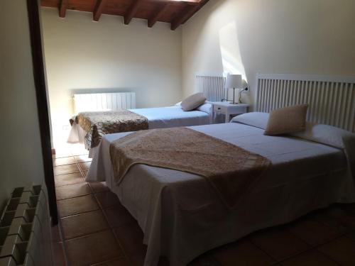 1 dormitorio con 2 camas y ventana en casa rural la Mariota, en Aldeadávila de la Ribera