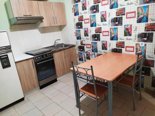 a kitchen with a table and chairs and a refrigerator at Новострой Прокофьева in Sumy