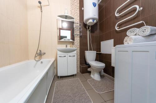 a bathroom with a tub and a toilet and a sink at Елизаветы Чавдар 34 in Kyiv