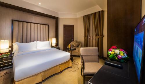 a hotel room with a large bed and a television at Boudl Mahayel Aseer in Muhayil