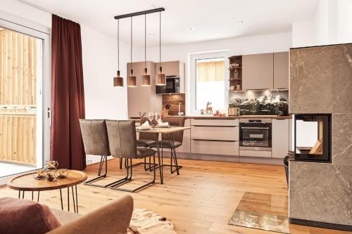 a kitchen and living room with a table and chairs at die Tauplitz Lodges - Alm Lodge A6 by AA Holiday Homes in Tauplitz