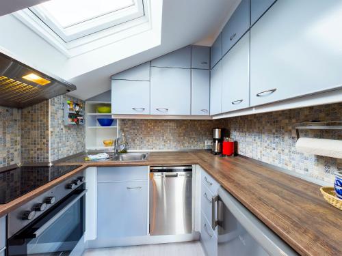 a kitchen with white cabinets and a wooden counter top at Chalet Alpenglühen in Garmisch-Partenkirchen