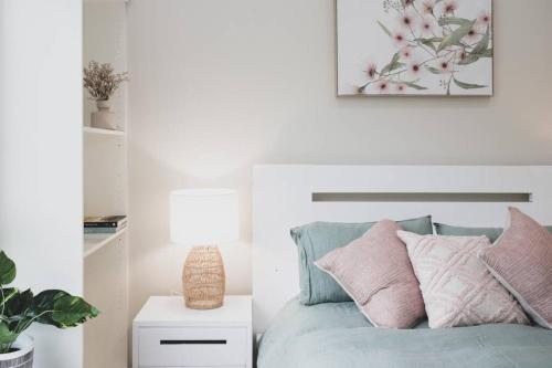 a bedroom with a bed with pink and grey pillows at Milton Woodstock Homestead Luxury retreat with NEW 11M POOL just minutes from the beach in Milton