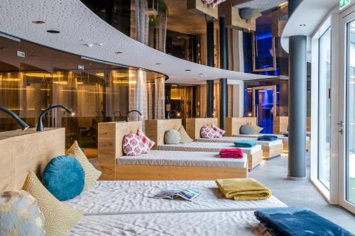 a hotel room with three beds and windows at Das Stemp Wellnessresort 4 Sterne Superior in Büchlberg