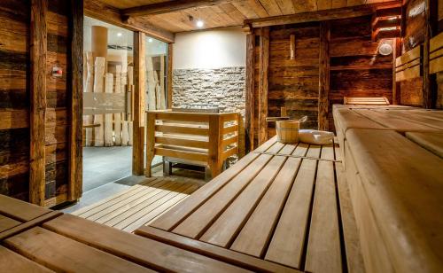 a sauna with wooden floors and a wooden table at Das Stemp Wellnessresort 4 Sterne Superior in Büchlberg