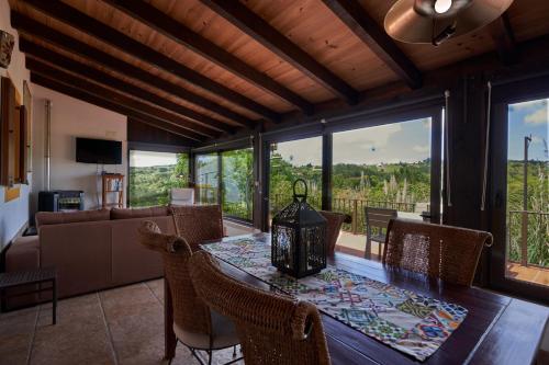a dining room with a table and chairs and a couch at Quinta do Bom Vento in Óbidos