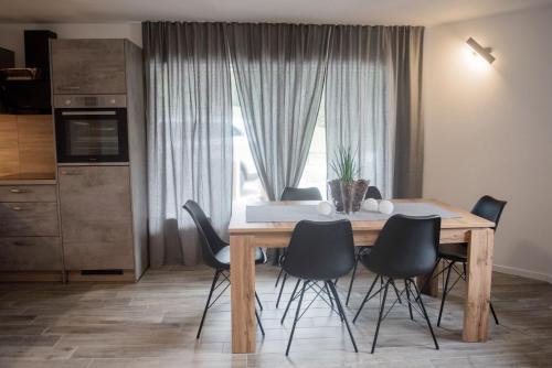 mesa de comedor con sillas negras y ventana grande en Apartment Lida, en Podčetrtek