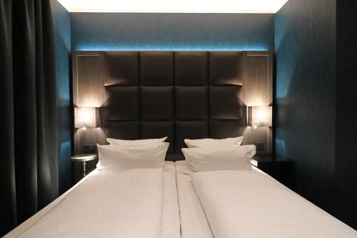 two beds with white pillows in a hotel room at Hotel Haverkamp in Bremerhaven