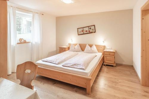 a bedroom with a large bed and a window at Apartments Silva Alpenblick in San Giovanni in Val Aurina