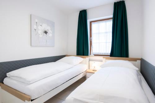 - 2 lits dans une chambre avec des rideaux verts dans l'établissement Alte Bergstrasse 6, Wohnung 3, à Scharbeutz