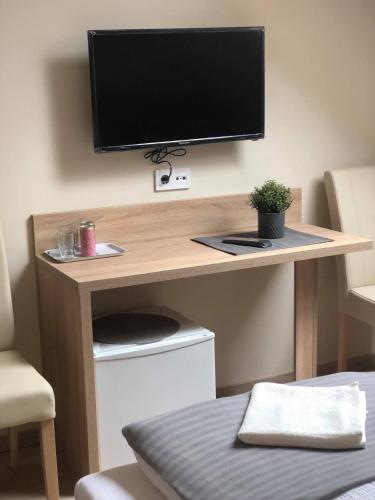 a desk with a television on top of it at Szőlőfürt Fogadó in Kecskemét