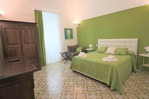 
a room with a bed, a table, a dresser, and a at Casa Assuntina in Positano

