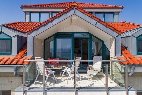 a patio with chairs and a table in front of a house at Turm-Appartement Strandburg in Fehmarn
