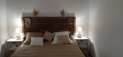 sypialnia z łóżkiem z 2 szafkami nocnymi i 2 lampami w obiekcie Chambre d'hotes Mas Pékin w mieście Mas-Thibert