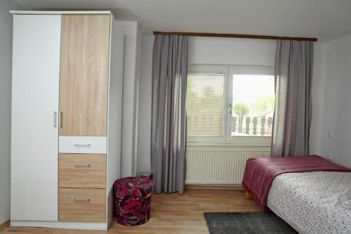 um quarto com uma cama, uma cómoda e uma janela em House Minka em Ptuj