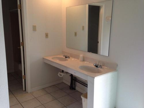 a bathroom with a sink and a mirror at Economy Inn - Lafayette in Lafayette