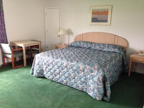 a hotel room with a bed and a table and a chair at Economy Inn - Lafayette in Lafayette