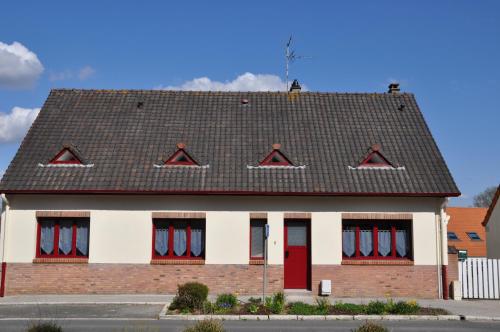 un bâtiment avec des portes rouges et un toit noir dans l'établissement Le Nid de Val'Ry, à Saint-Valery-sur-Somme