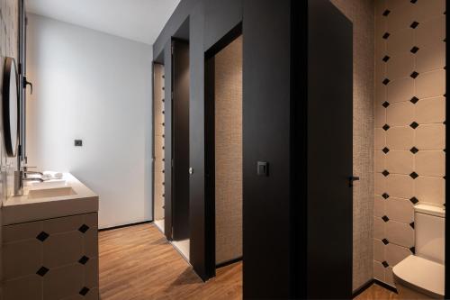 a bathroom with a black door and a sink at TOC Hostel Malaga in Málaga