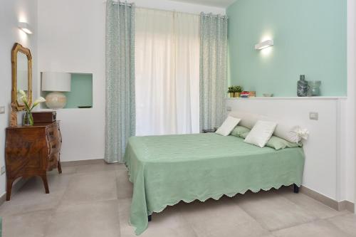 a bedroom with a bed with a green blanket at Casamari Apartments in Maiori