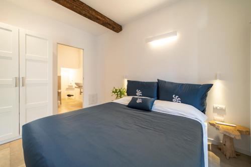 a bedroom with a blue bed in a white room at Albergo Diffuso Vulcano Village in Castro