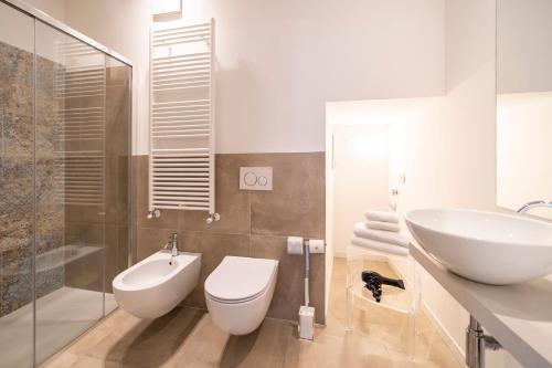 a white bathroom with a sink and a toilet at Albergo Diffuso Vulcano Village in Castro