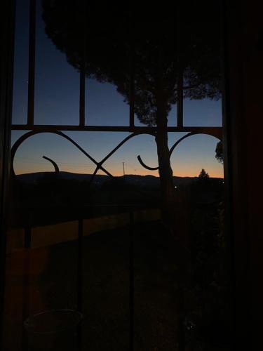 a view of a sunset through a window with a tree at Tognazzi Casa Vacanze - La Collina di San Gimignano in San Gimignano