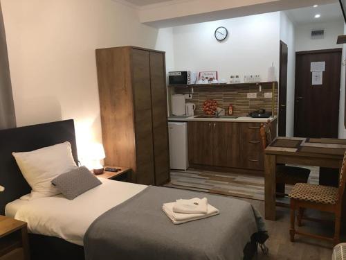 mały pokój z łóżkiem i kuchnią w obiekcie Aranykorona Apartmanház w Miszkolcu