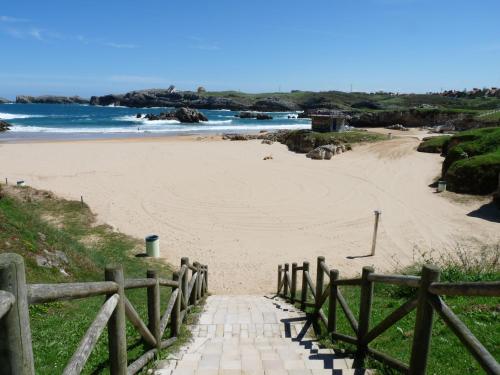 a path leading to a sandy beach with the ocean at Apartamentos Maradentro in Soto de la Marina