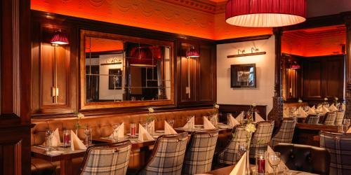a restaurant with tables and chairs and a mirror at Grand Hotel Tralee in Tralee