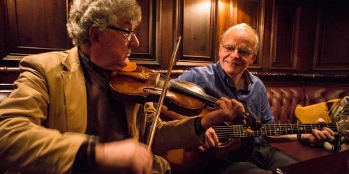 a man playing a violin and a man playing a guitar at Grand Hotel Tralee in Tralee