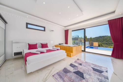 a white bedroom with a bed and a large window at Corleone - Modern Villa with Jacuzzi in Kalkan in Kaş