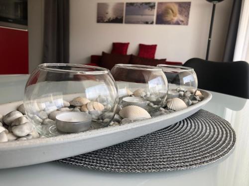 a tray with shells and glasses on a table at Vier Jahreszeiten 3-14 in Großenbrode